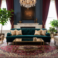 Green velvet sofa with tufted backrest on a concrete floor.